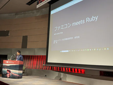 A speaker at RubyWorld. The slide reads "NES meets Ruby"