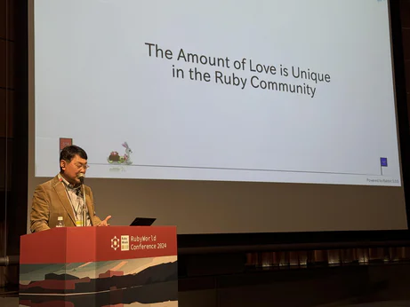 Matz on stage in front of a slide that reads "The amount of love is unique in the Ruby community"